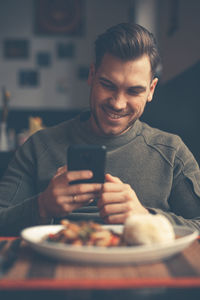 Midsection of man using mobile phone