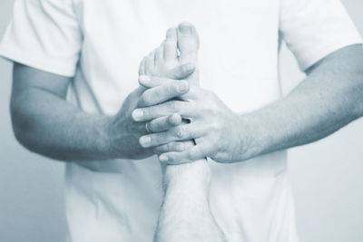 Midsection of doctor examining foot