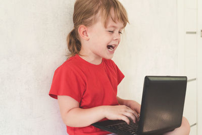 Smiling child learn online, play, have fun or chat with friends. 