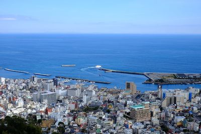 High angle view of sea by buildings against sky