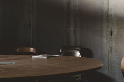 Empty chairs and table against wall