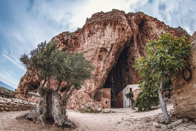 Grotta mangiapane-rock formations on beach against sky