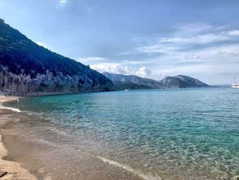 Scenic view of sea and mountains against sky