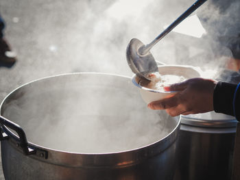 Close-up of person preparing food on barbecue grill