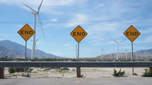 Road sign against wind turbines
