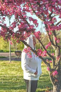 Rear view of woman standing by tree