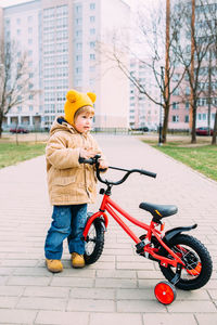 A small child learns to ride a bike for the first time in the city in spring