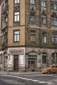 Cars on road by building in city