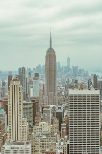 Empire state building from far against sky and buildings in background