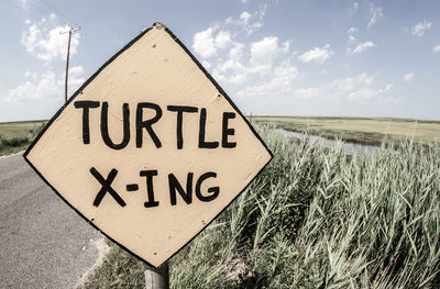 Information sign against cloudy sky