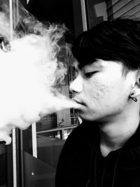 Portrait of young man smoking cigarette