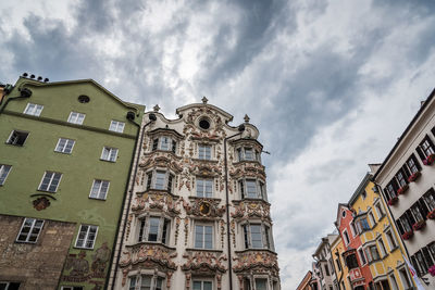 Low angle view of buildings against cloudy sky