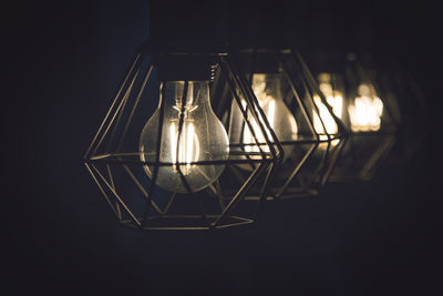 Close-up of illuminated light bulbs in dark room