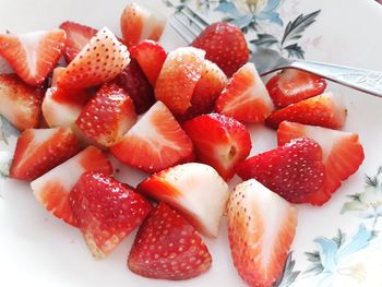 High angle view of chopped strawberries in plate