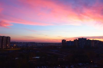 Modern buildings against sky during sunset