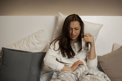 Young woman sitting on sofa at home