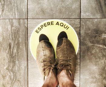 Low section of man standing on tiled floor