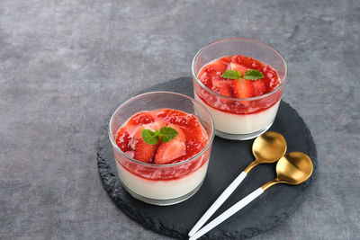 Sweet vanilla silky pudding dessert with strawberry sauce, sliced fresh strawberries and mint 