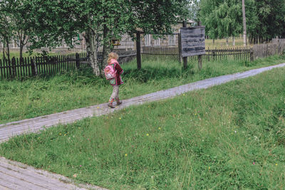 A girl in casual clothes walks around the outskirts of the village, russian hinterland