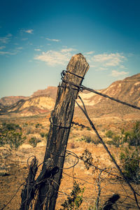 View of wooden fence on land against sky