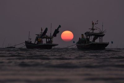 Silhouette of ship at sea against sky during sunset