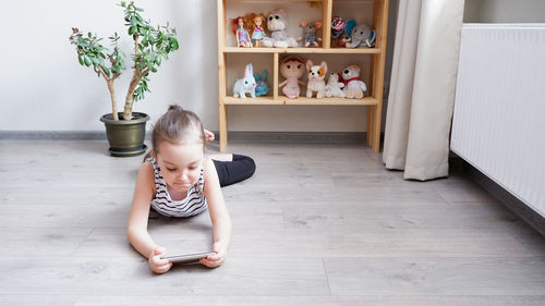 Full length of cute boy sitting on floor at home