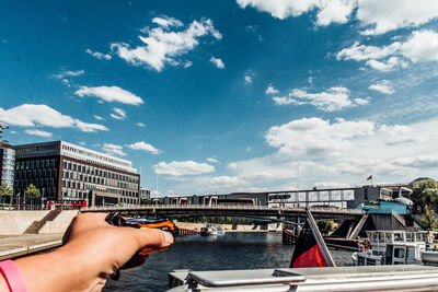 Close-up of hand against boat in river