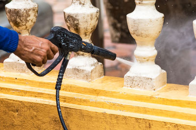 Man cleaning balustrade with water spray 