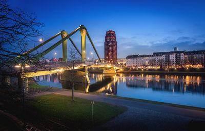 Illuminated bridge over river at night