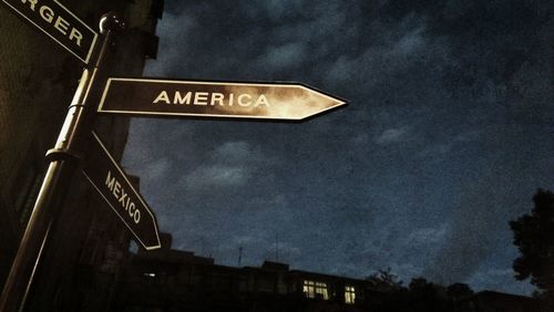 Low angle view of sign board against sky