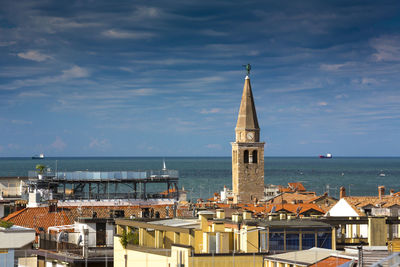 Buildings by sea against sky in city