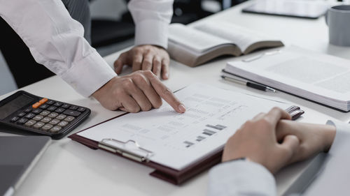 Midsection of business colleagues working at desk in office