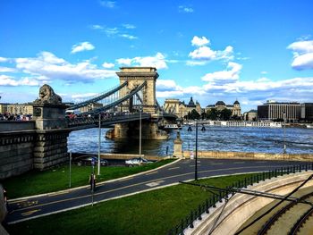 Bridge over river against sky in city