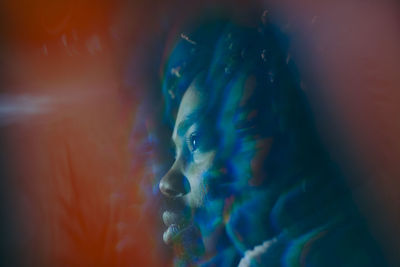 Double exposure of young man looking away at illuminated restaurant