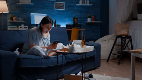 Woman sitting on table at home