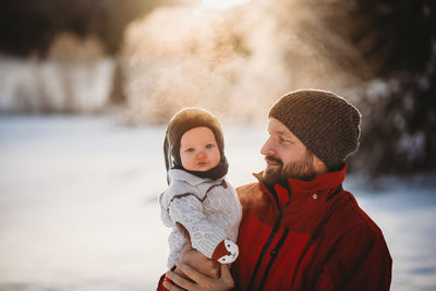 Full length of a smiling man with snow during winter