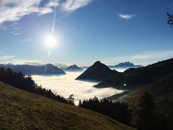 Scenic view of landscape against bright sun