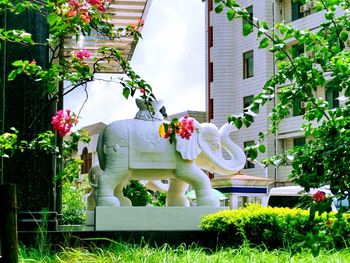 Statue against trees and building in city