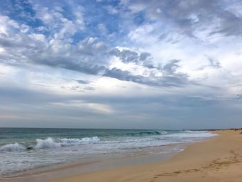 Scenic view of beach and cloudy sky