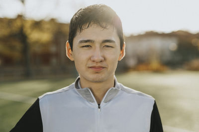 Portrait of confident male athlete at sports field