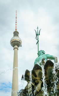 Low angle view of communications tower in city
