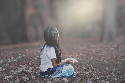 Full length of woman sitting on field