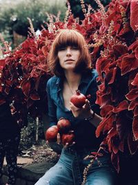 Full length of woman with red leaves during autumn