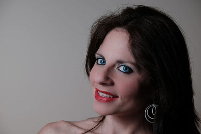 Portrait of smiling young woman against white background