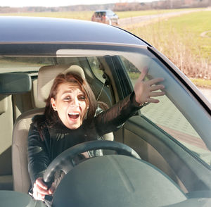 Woman shouting while driving car on road