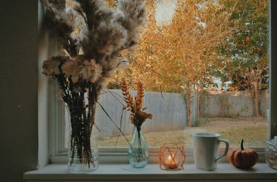 Flower vase on table against wall