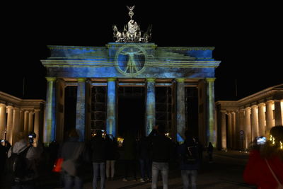 Group of people in front of historical building at night