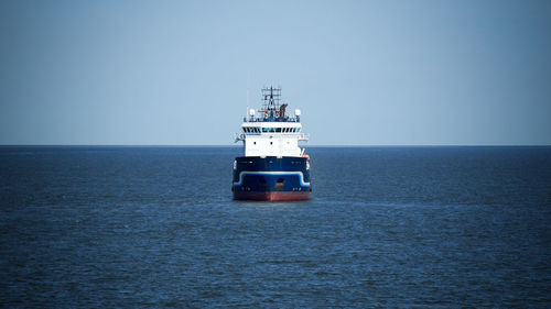 Ship sailing on sea against clear sky