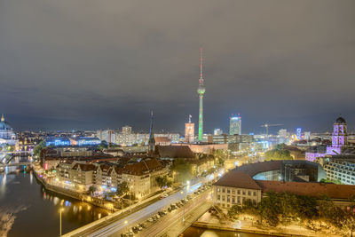 Illuminated cityscape against sky at night