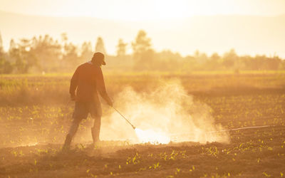 Farmer working in farm during sunset